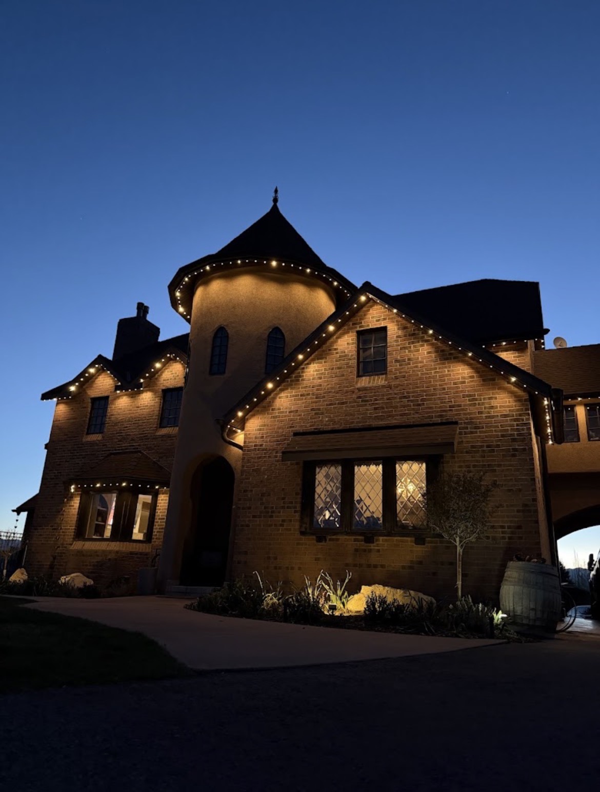 Warm white roofline lights on a brick home